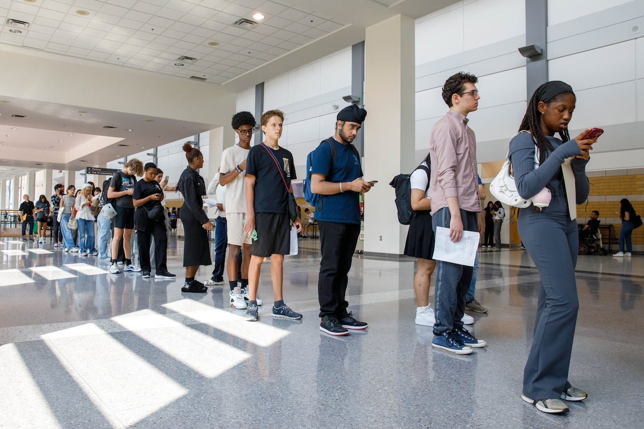 default-201 young people hold resumes in a long queue in a convention centre