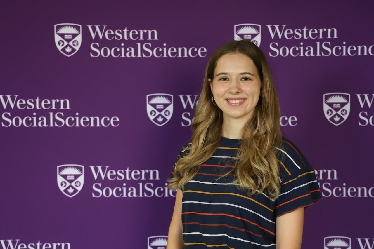 student stands in front of a western decal wall