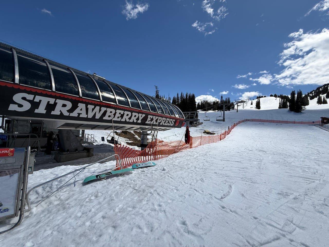 A ski lift on a snowy mountain under blue skies.