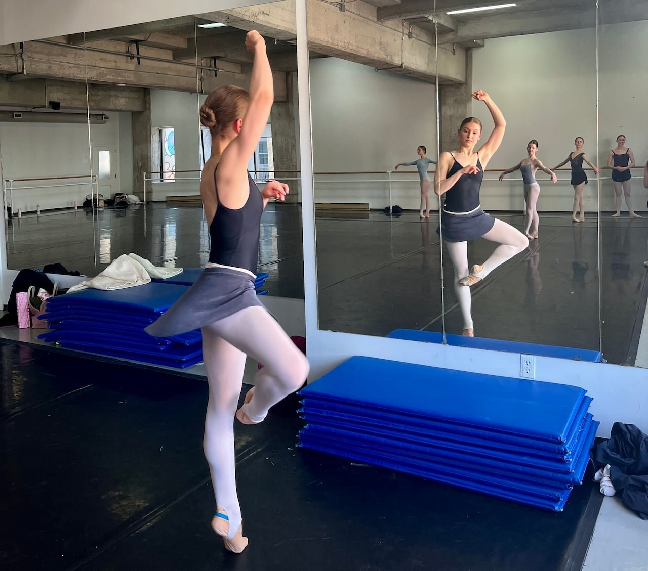 A ballet dancer posing in the mirror.
